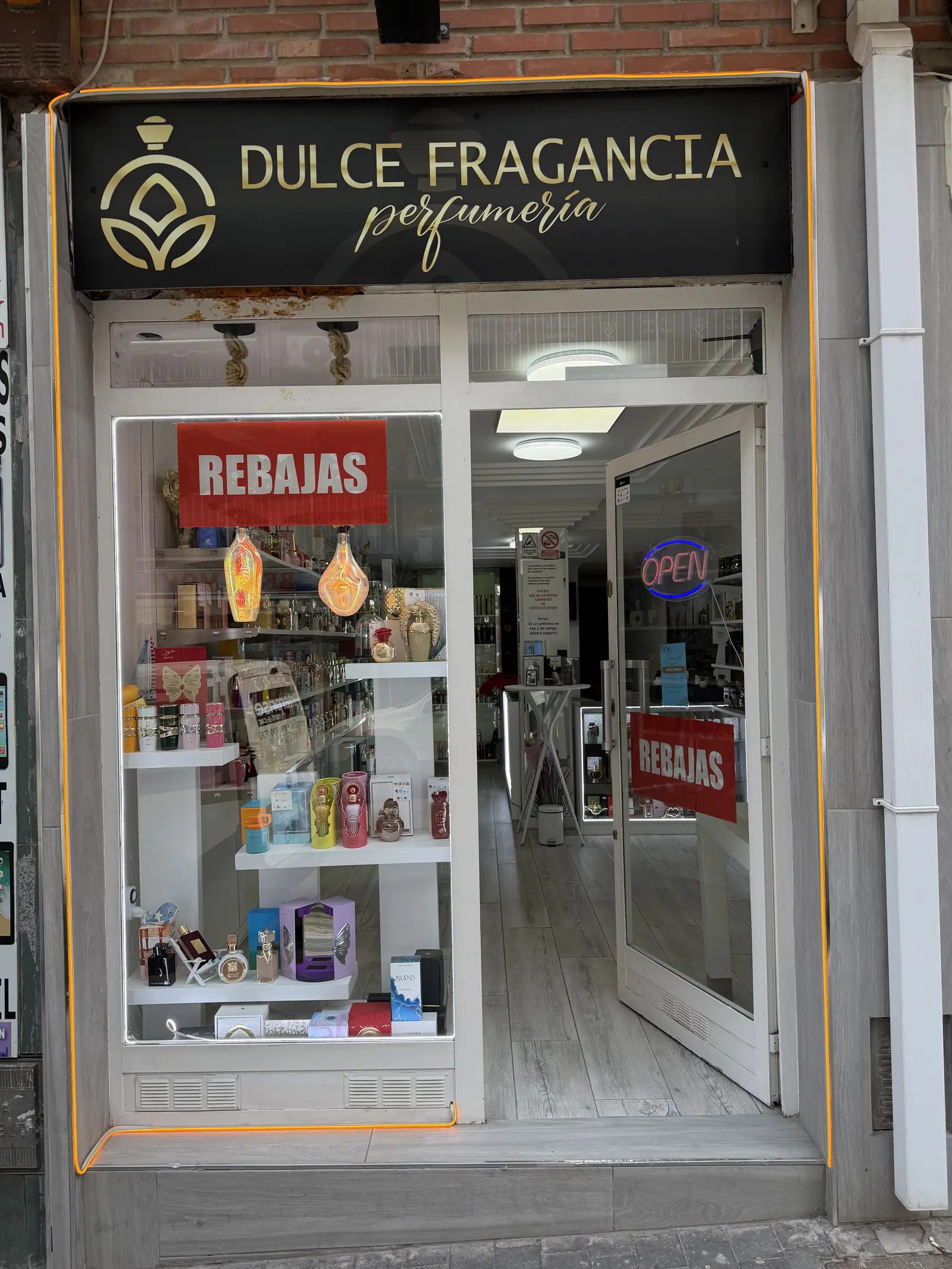Entrada de la tienda con el escaparate y el cartel de abierto